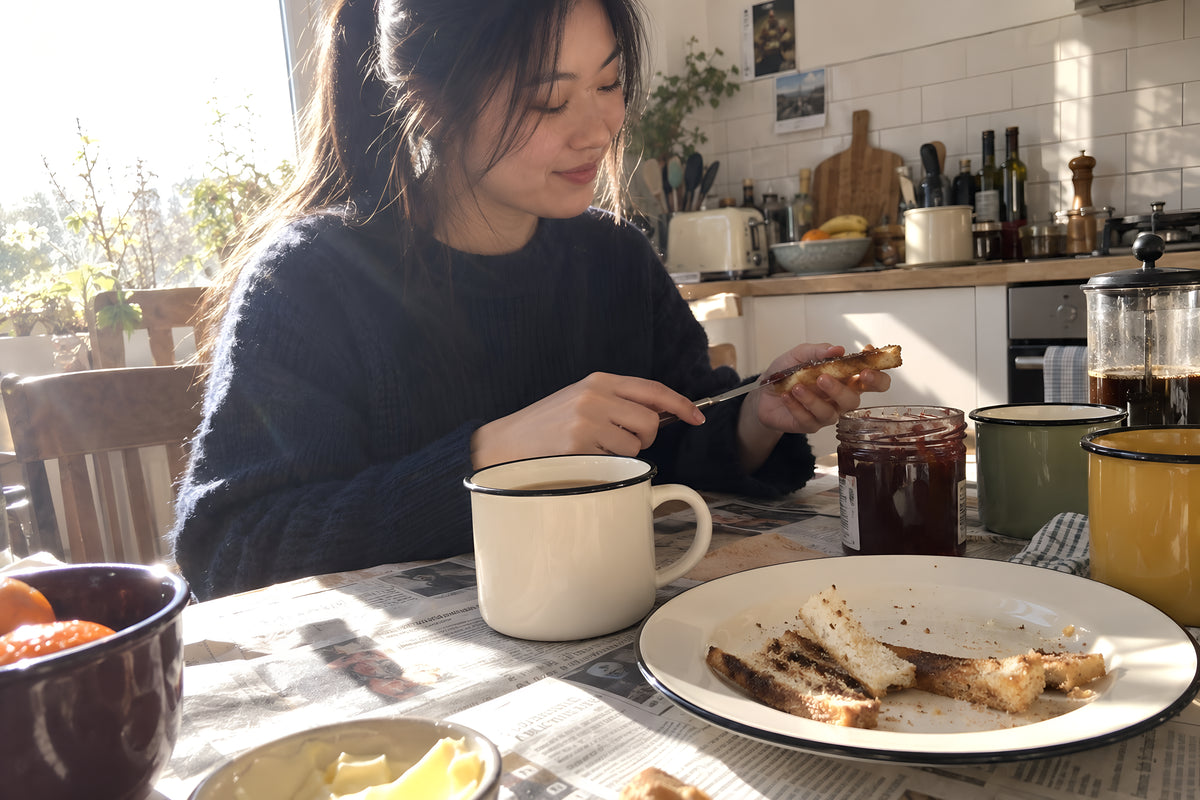 Sunday morning at a table covered in newspapers, KILN mugs and a plate of toast crusts, two people not talking and perfectly happy. Daytime, hard sun, no candles lit.