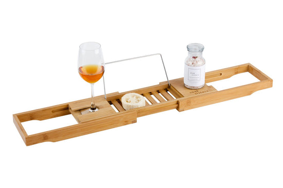Bamboo bath caddy with glass of wine in glass holder and jar of bath salts on top